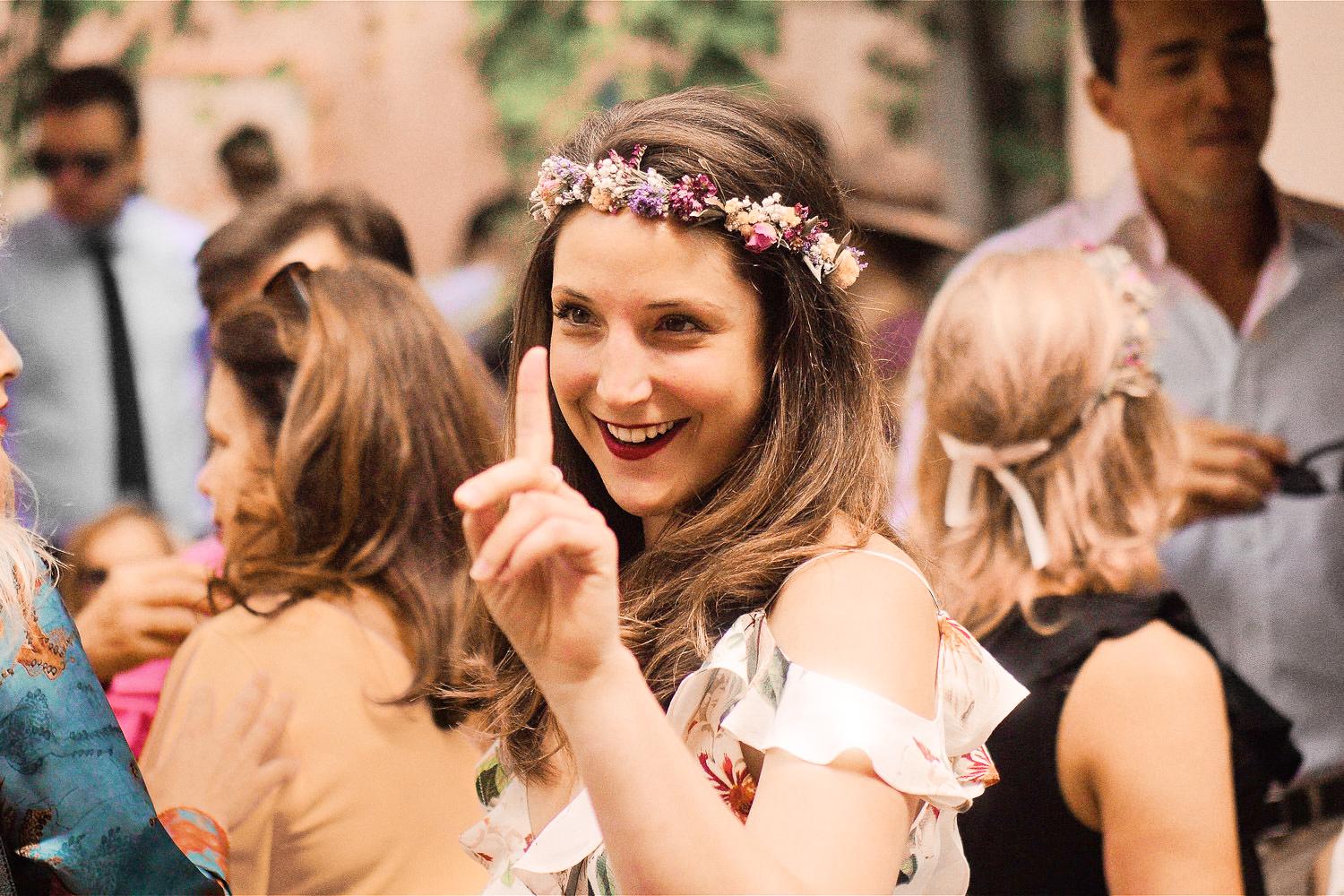 Bridesmaid with flowers in her hair, raises her finger