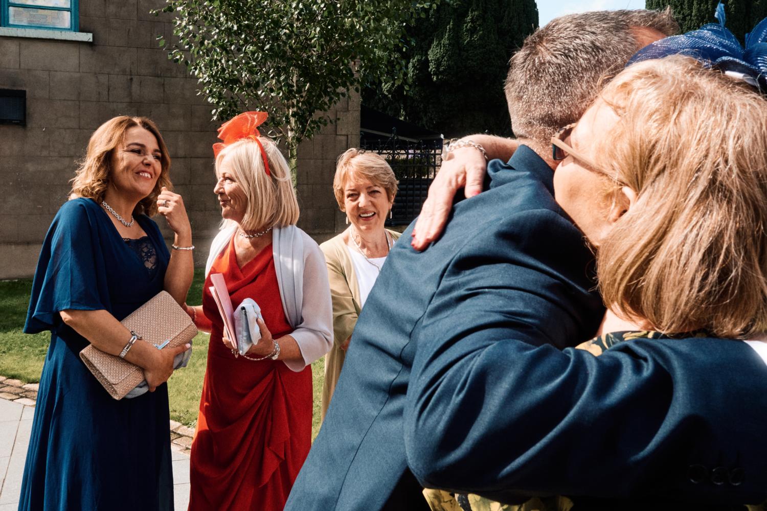 Wedding guests greet each other outside a chapel