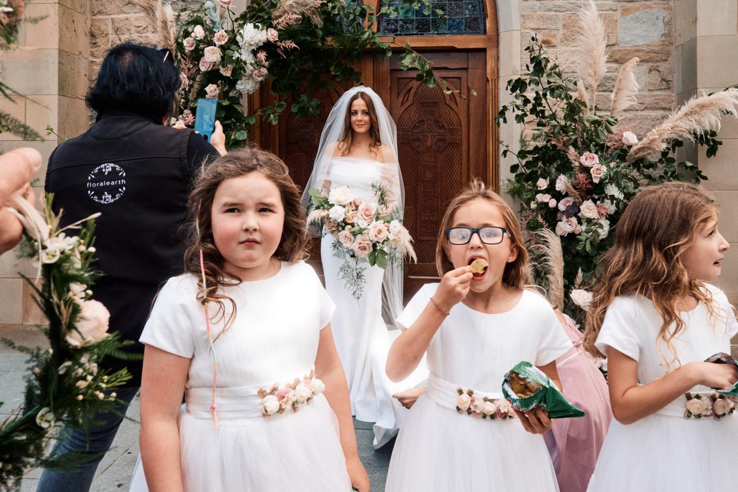 Flower girls eating crisps in front of a bride in Dungannon