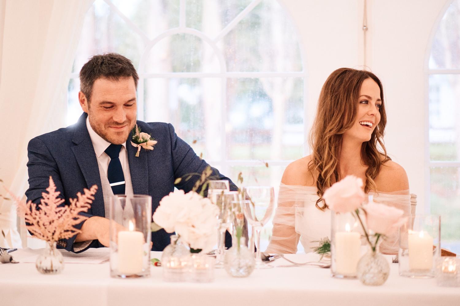 A married couple smile as they listen to the speeches