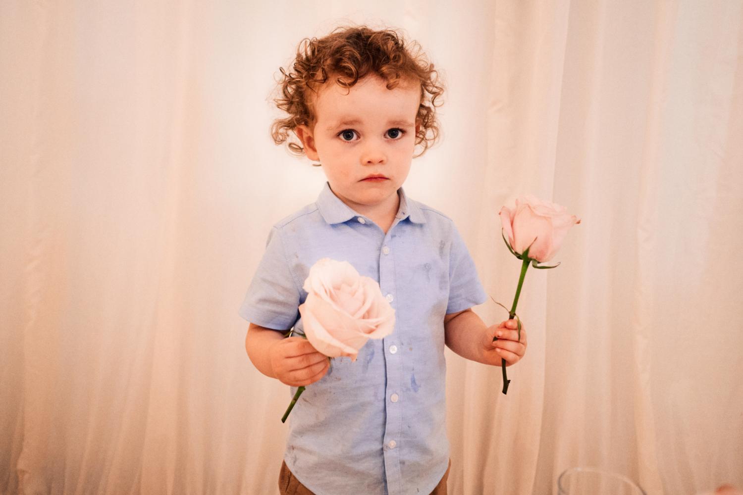 A child steals two roses at a wedding