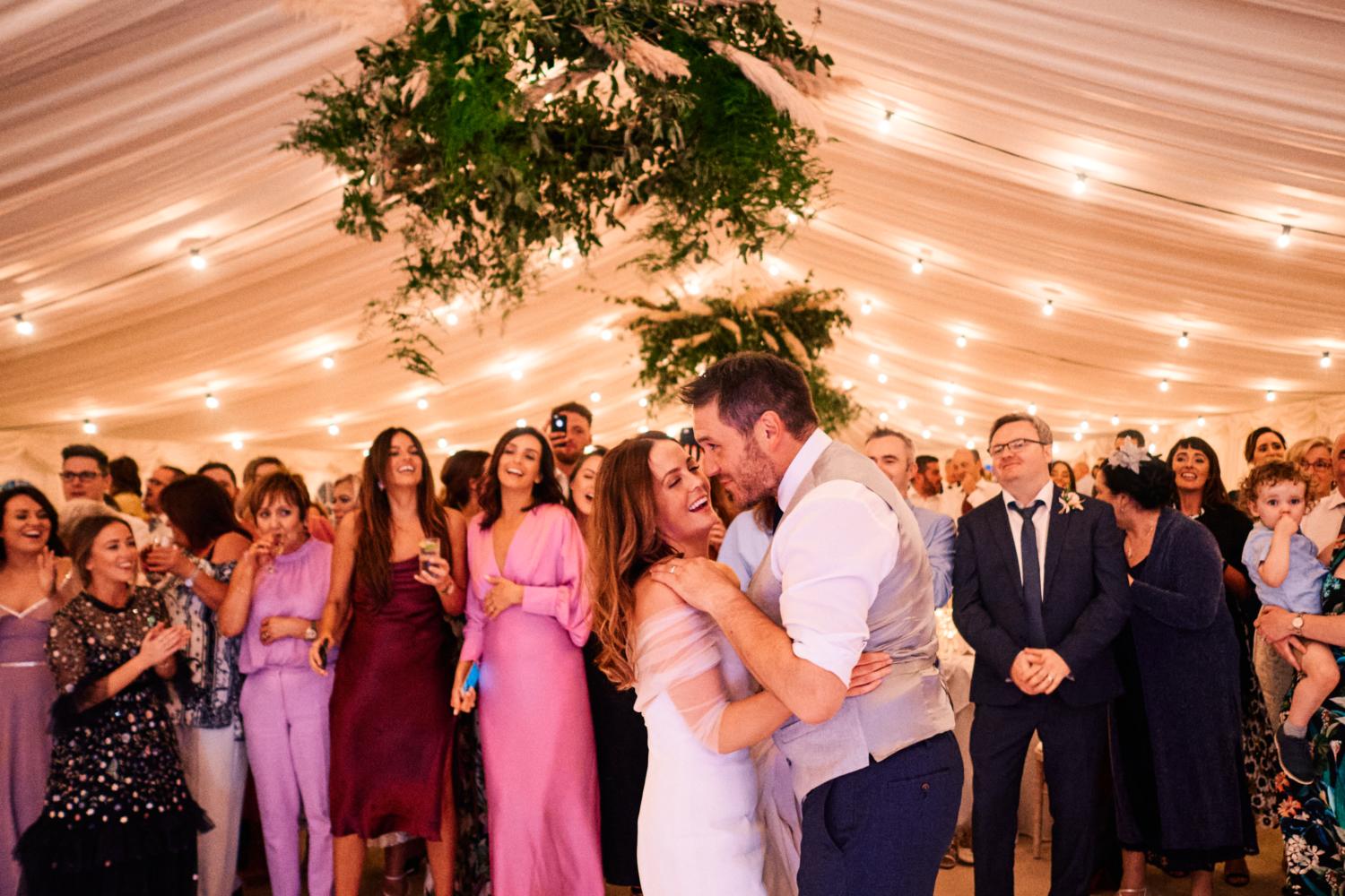 Guests watching the first dance in a marquee