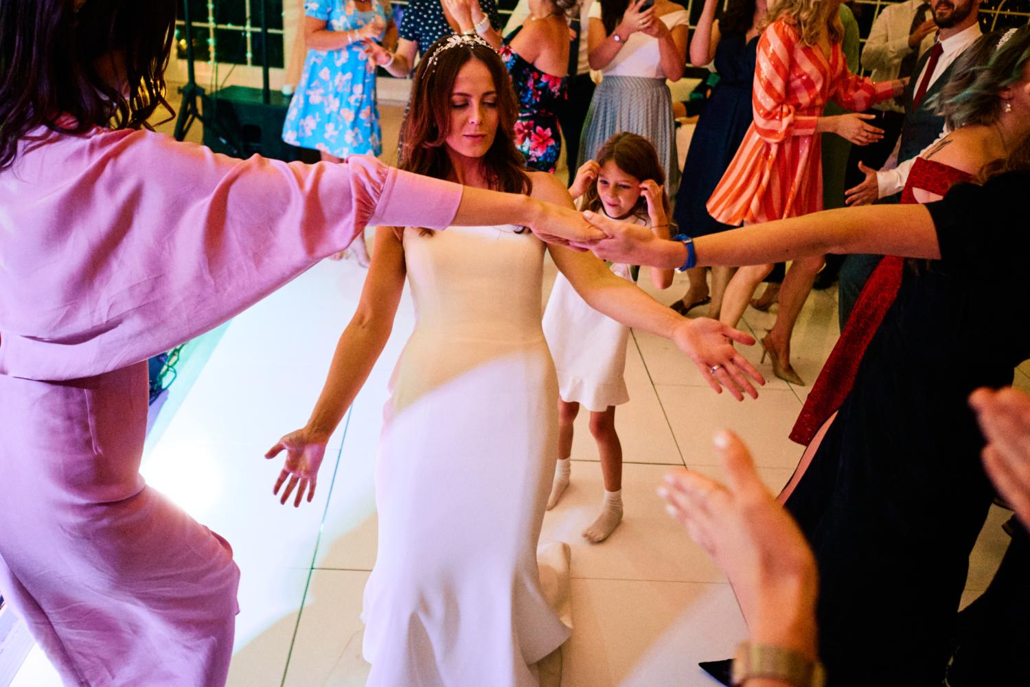 A bride plays limbo at a wedding