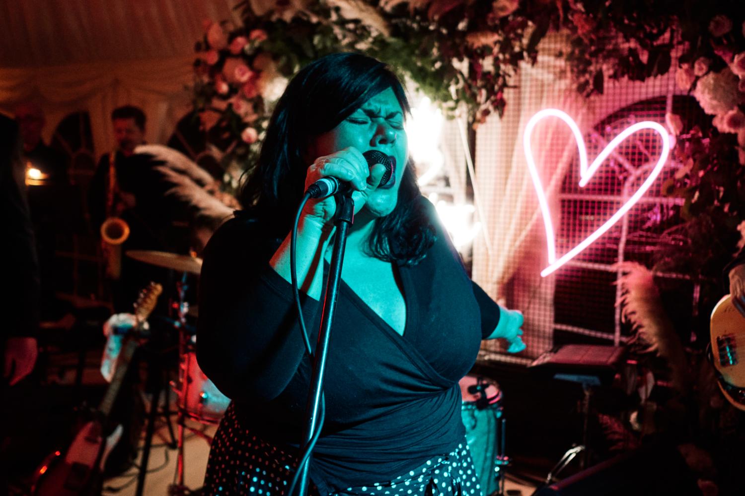 An expressive singer at a wedding, bathed in blue light