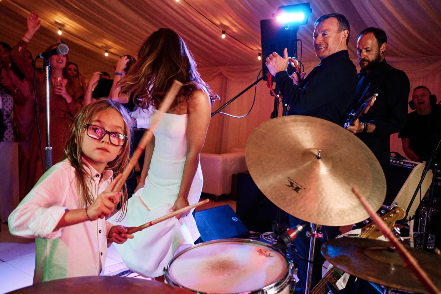 A child plays the drums at a wedding