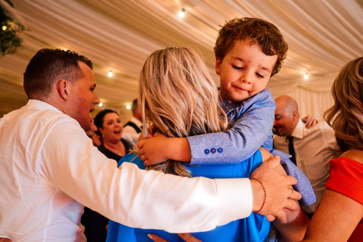 A child hugs his mother at wedding