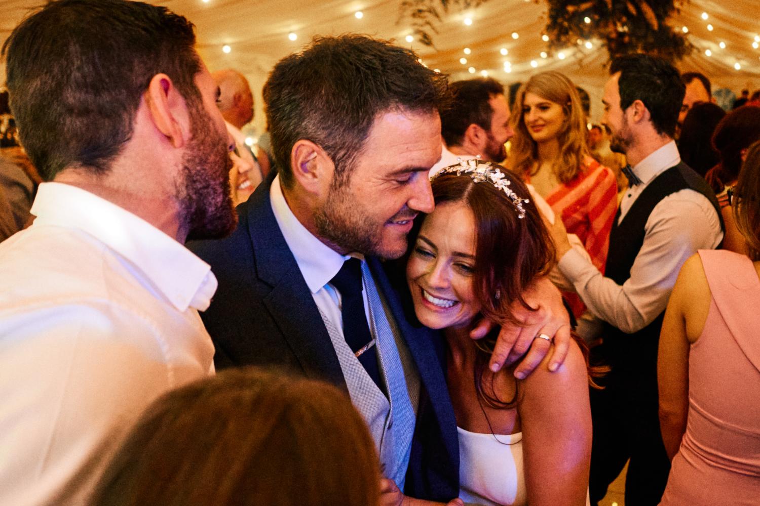 Bride and groom hug on the dancefloor