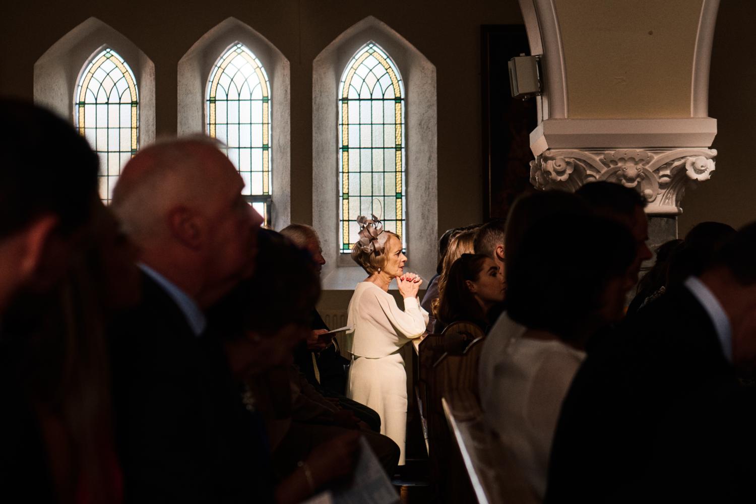 A woman prays during an Irish wedding mass