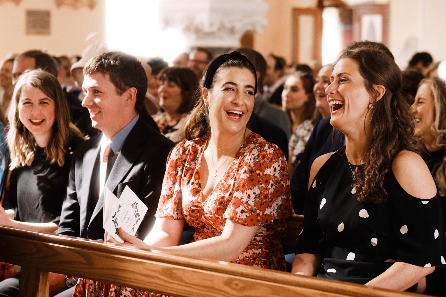 Wedding guests laugh during a wedding ceremony