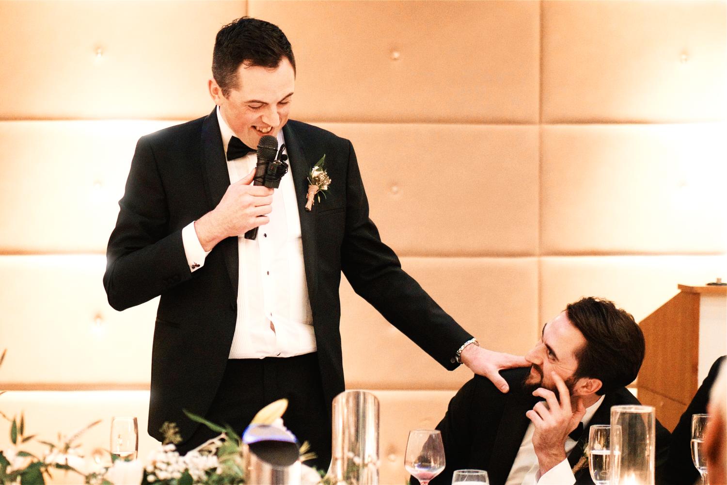 Groom affectionately touches his brother's shoulder during the speeches