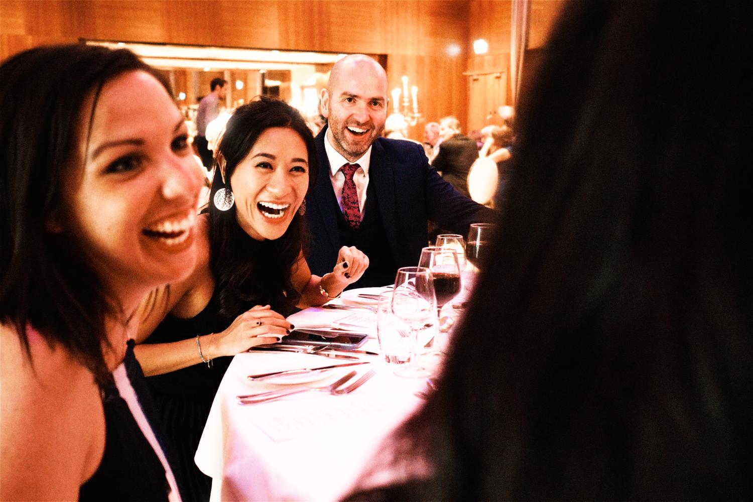 Wedding guests laugh at an evening reception