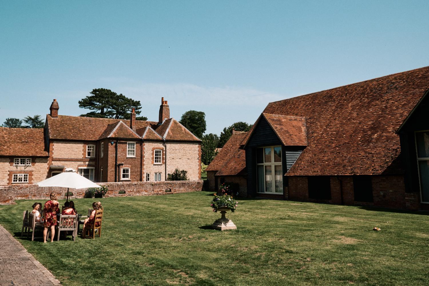 Bridal party relax outside at Ford's Farm, Ewelme