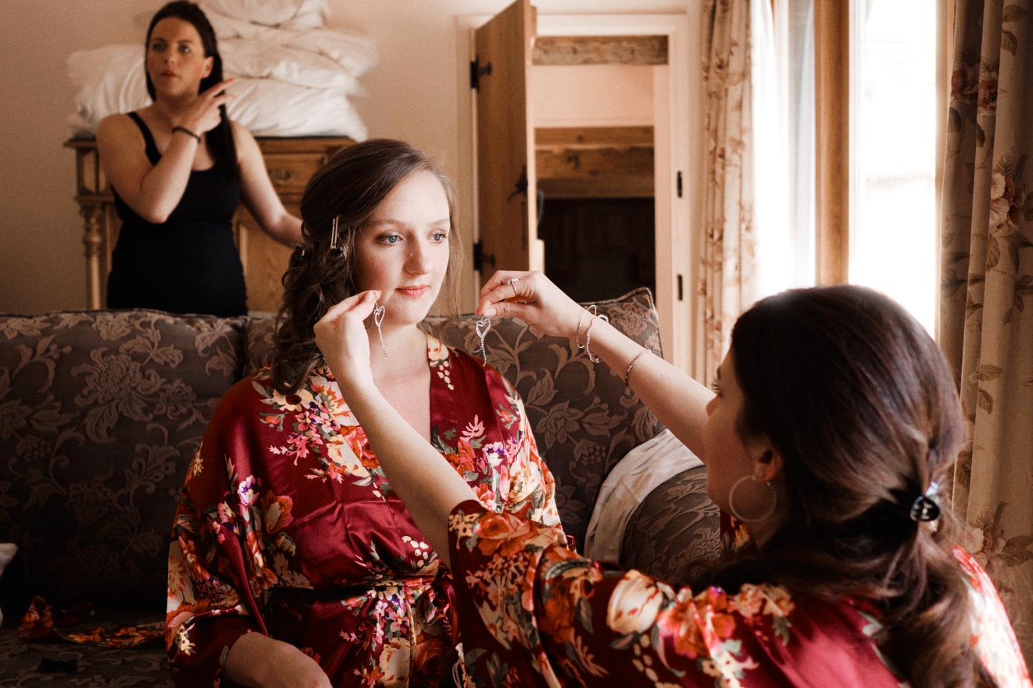 A bridesmaid helps a bridesmaid pick earrings