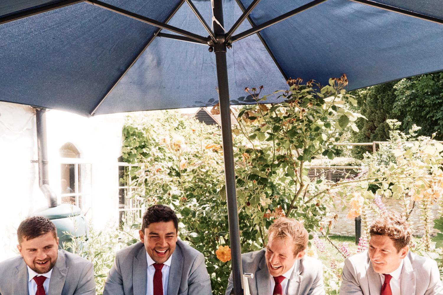 Groomsmen and three friends sit at a picnic bench