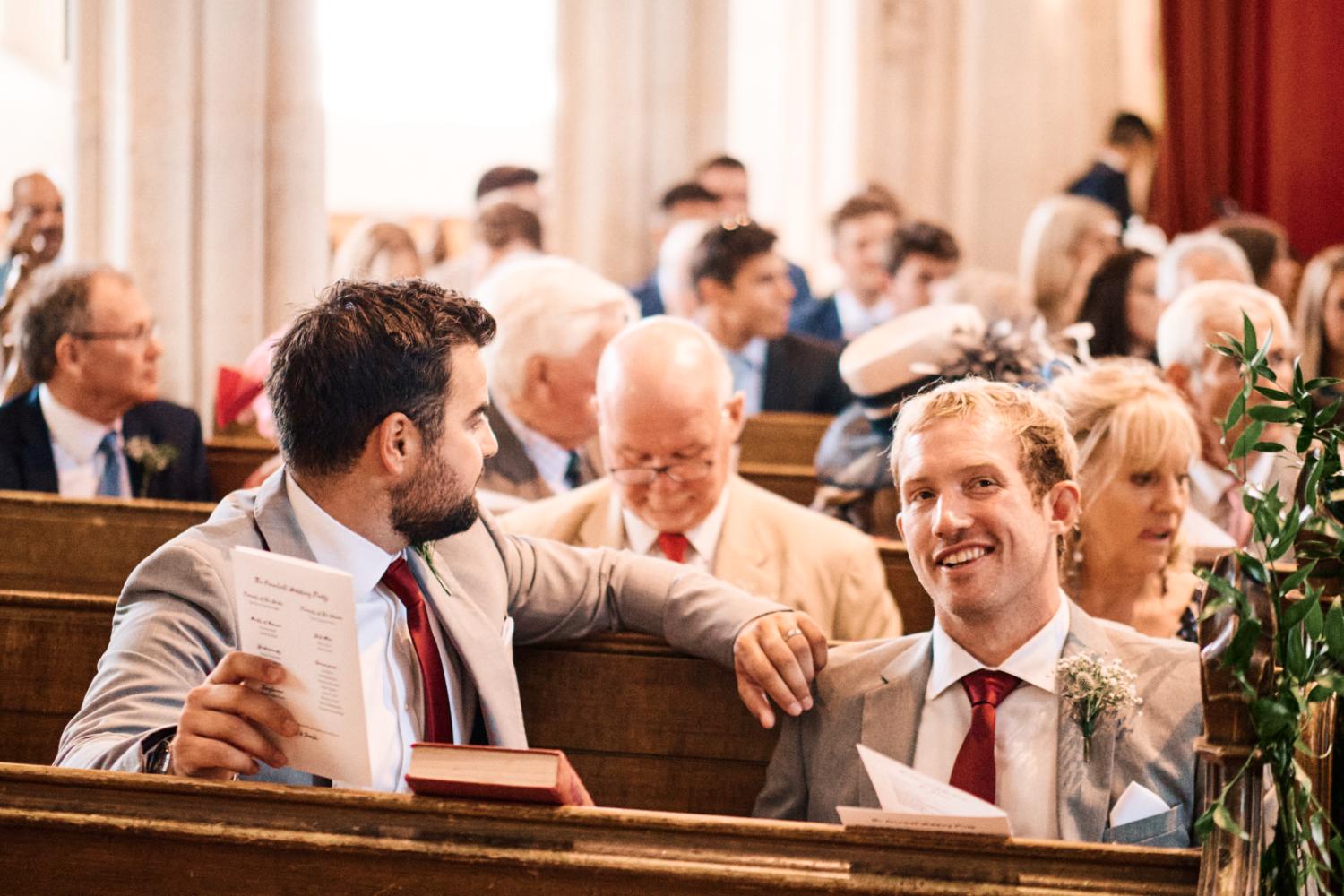 A groom smiles in a church