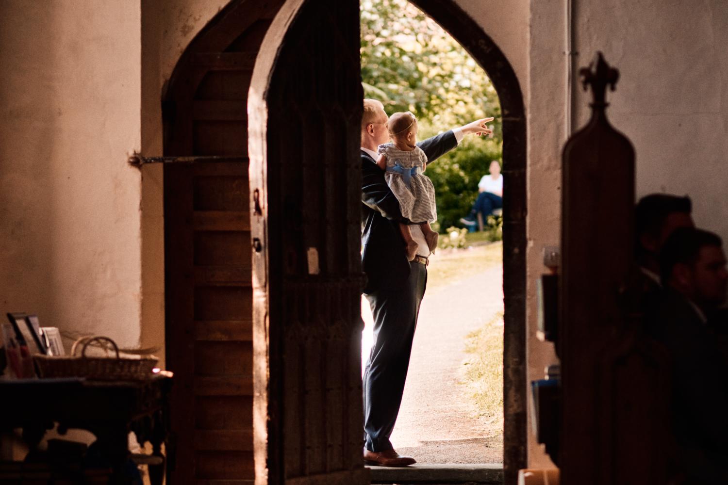 A father points to something outside a church
