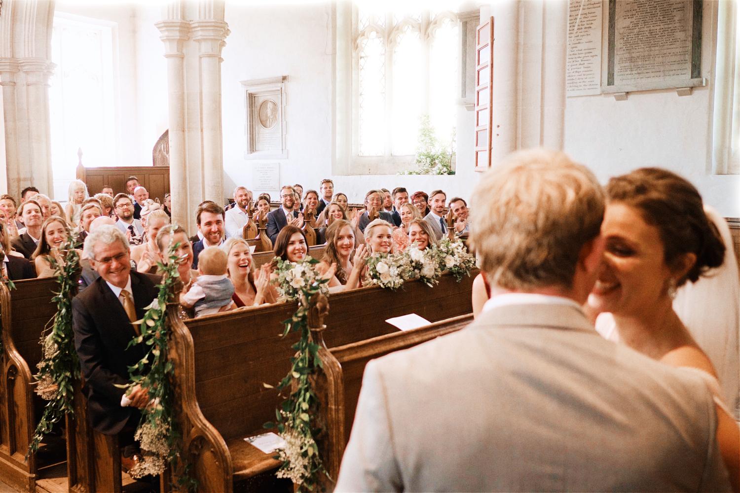 Guests cheer a newly wedded couple in a church