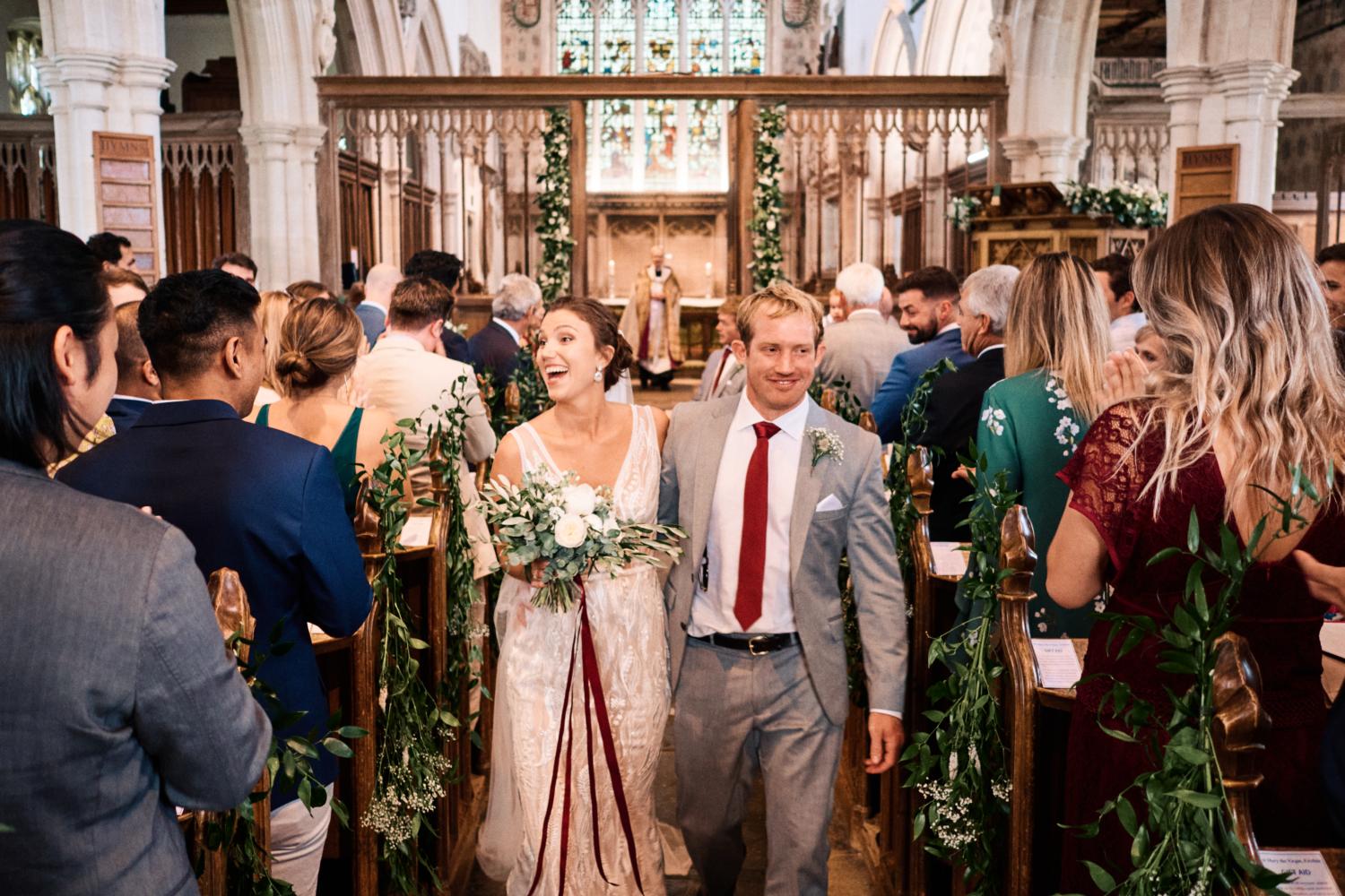 Bride and groom walk down the aisle at Ewelme Church