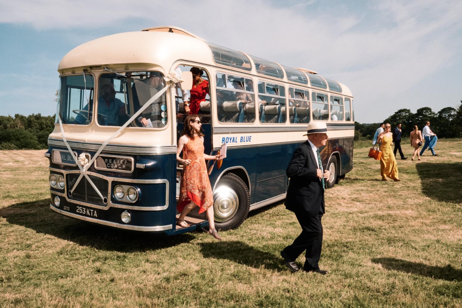 Wedding guests arrive on a blue Vintage bus