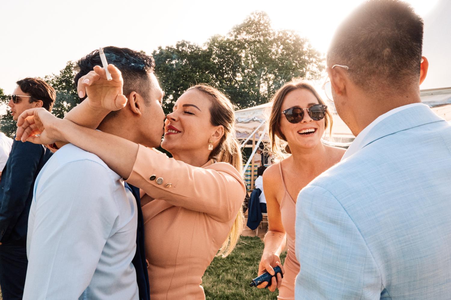 A couple kiss outside a marquee