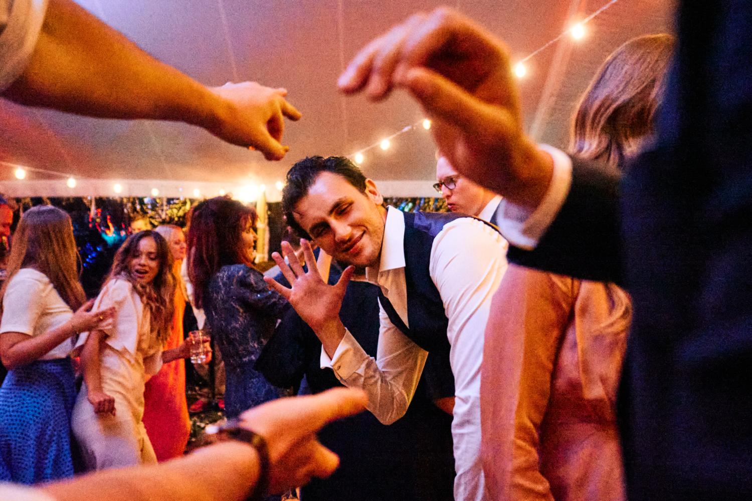 Expressive hands frame a smiling dancer on the dancefloor